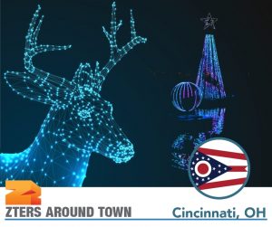 Cincinnati Zoo Festival of Lights depicted by lit up blue deer head with illuminated tree and sphere in background.