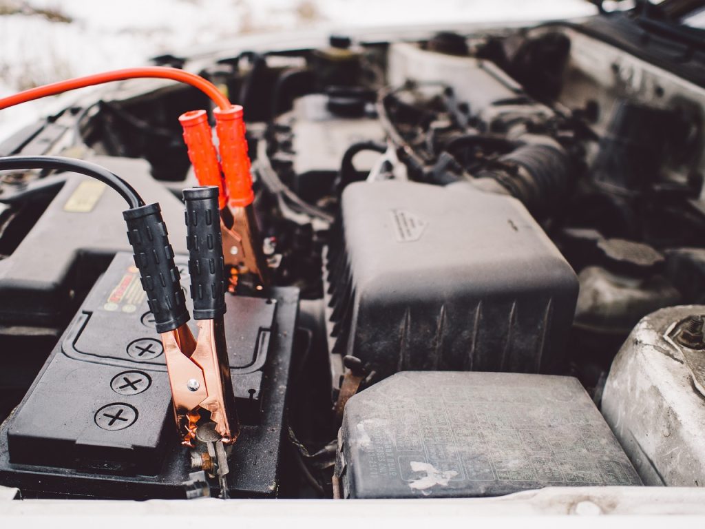 A picture of a car battery with jumper cables connected to it