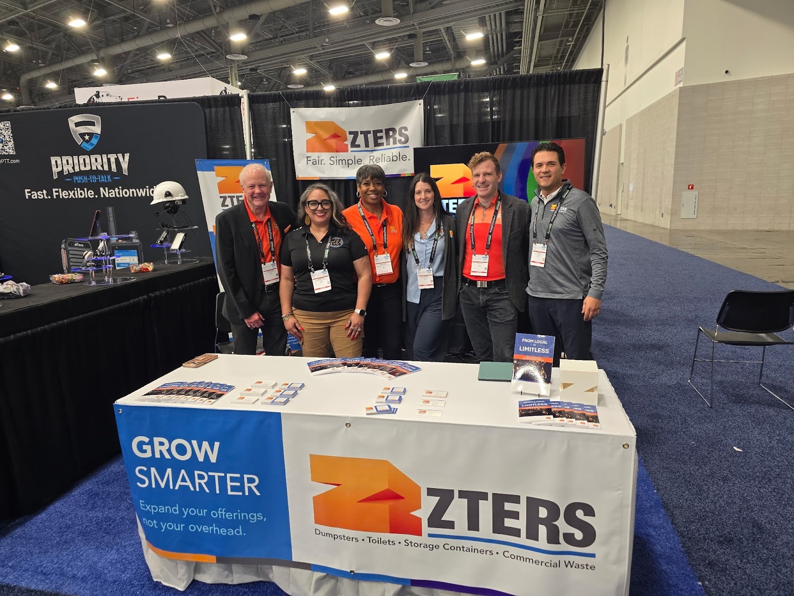 An image of a group of ZTERS employees at an expo standing behind a branded table.
