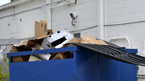 Overflowing cardboard dumpster highlighting the need to optimize waste management and recycling efficiency.