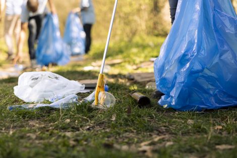 How to stop littering in your community illustrated by volunteers collecting plastic waste during a local cleanup.