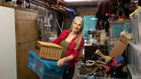 A smiling woman spring cleaning and decluttering her garage