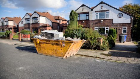 A photo of a full dumpster outside of a home .
